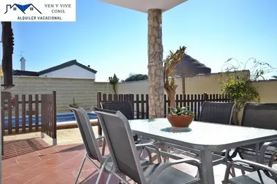 a table and chairs on a patio at Chalet con Piscina privada en Conil in Conil de la Frontera