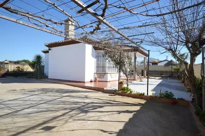 a house with a white garage in a driveway at Chalet con Piscina privada en Conil in Conil de la Frontera
