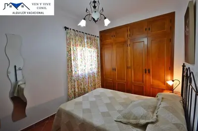 a bedroom with a bed with a dresser and a window at Chalet con Piscina privada en Conil in Conil de la Frontera