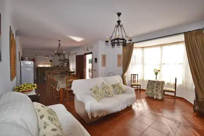 a living room with a white couch and a dining room at Chalet con Piscina privada en Conil in Conil de la Frontera
