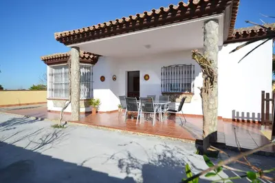 a patio of a house with a table and chairs at Chalet con Piscina privada en Conil in Conil de la Frontera