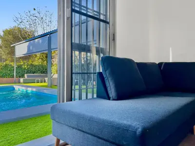 a blue couch sitting next to a swimming pool at Villa San Patricio I Piscina Privada I Jacuzzi Spa I BBQ I PS5 I Aire Acon I 3000m2 I 5min-Centro in Jerez de la Frontera