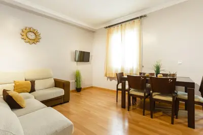 a living room with a couch and a table with chairs at Apartamento con patio en Cádiz centro in Cádiz