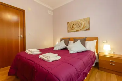 a bedroom with a red bed with towels on it at Apartamento con patio en Cádiz centro in Cádiz