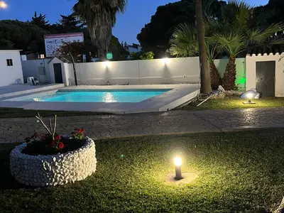 a yard with a pool and a candle in the grass at Villa Sagrario in Chiclana de la Frontera