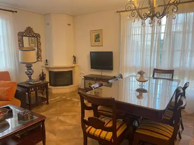 a living room with a table and a television at Villa Sagrario in Chiclana de la Frontera