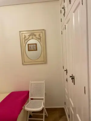 a room with a chair and a picture on the wall at Villa Sagrario in Chiclana de la Frontera