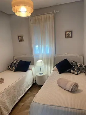 a bedroom with two beds and a lamp in it at Villa Sagrario in Chiclana de la Frontera