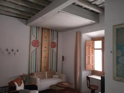 a living room with a white couch and a window at La gota de leche 3 in Sanlúcar de Barrameda