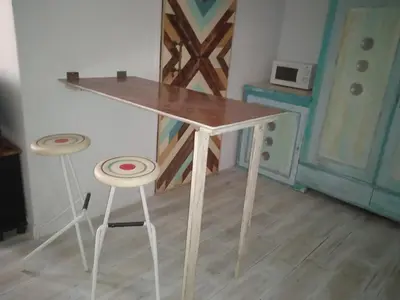 a wooden table and two stools in a room at La gota de leche 3 in Sanlúcar de Barrameda