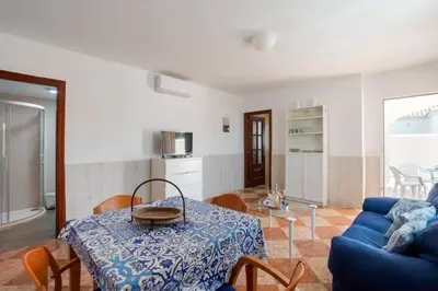 a living room with a table and a blue couch at El Verano Azul Casa con piscina in Chiclana de la Frontera