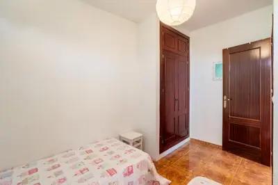 a bedroom with a bed and a wooden door at El Verano Azul Casa con piscina in Chiclana de la Frontera