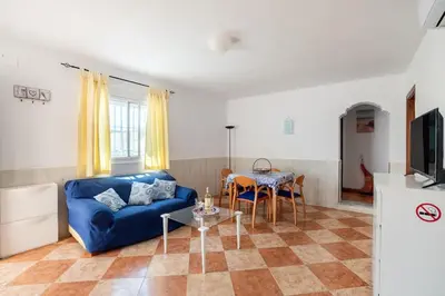 a living room with a blue couch and a table at El Verano Azul Casa con piscina in Chiclana de la Frontera