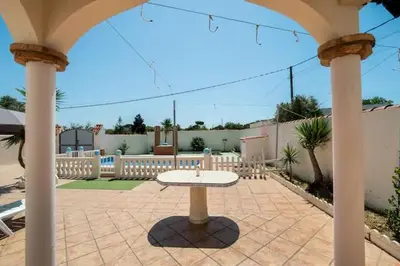a stone patio with a table in a pavilion at El Verano Azul Casa con piscina in Chiclana de la Frontera