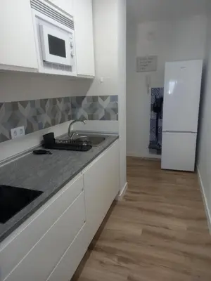 a white kitchen with a sink and a microwave at Primera línea Valdelagrana in El Puerto de Santa María