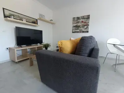 a living room with a couch and a television at Apartamento Red de Almadraba in Chiclana de la Frontera