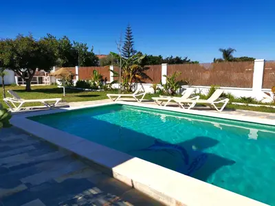 a swimming pool with lounge chairs in a yard at Olas de Conil in Conil de la Frontera