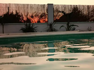 a swimming pool with reflections in the water at Olas de Conil in Conil de la Frontera