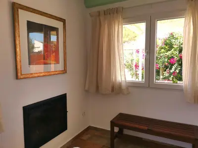 a living room with a flat screen tv and two windows at Olas de Conil in Conil de la Frontera