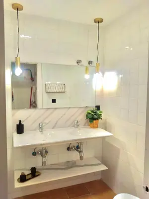 a bathroom with two sinks and a mirror at Primera linea playa valdelagrana vistas al mar in El Puerto de Santa María