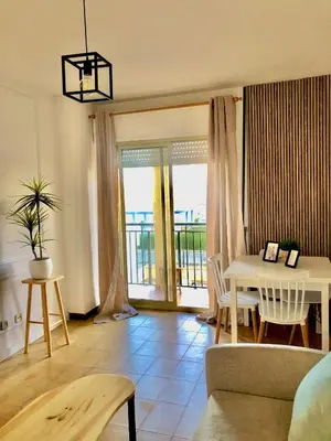 a living room with a couch and a table at Primera linea playa valdelagrana vistas al mar in El Puerto de Santa María
