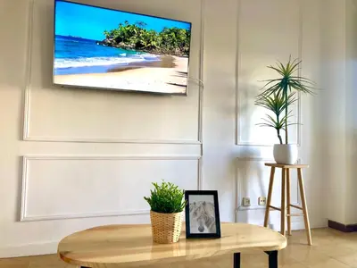 a living room with a tv hanging on a wall at Primera linea playa valdelagrana vistas al mar in El Puerto de Santa María