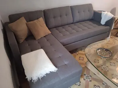 a blue couch in a living room with a glass table at La gota de leche 2 in Sanlúcar de Barrameda
