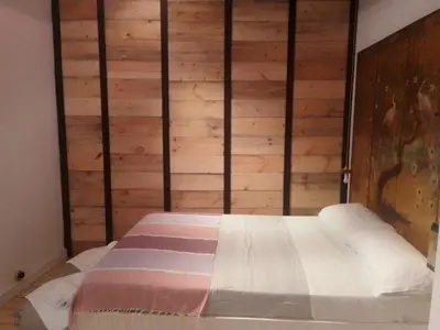 a bed in a room with a wooden wall at La gota de leche 2 in Sanlúcar de Barrameda