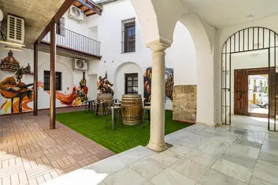 an indoor patio with a table and chairs and a mural at Allo Apartments Arroyo Catedral in Jerez de la Frontera