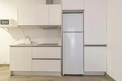 a kitchen with white cabinets and a refrigerator at Allo Apartments Arroyo Catedral in Jerez de la Frontera
