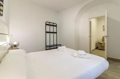 a white bed with two towels on top of it at Allo Apartments Arroyo Catedral in Jerez de la Frontera