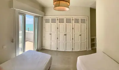 a bedroom with two beds and a large window at Espectacular apartamento frente al mar in El Puerto de Santa María