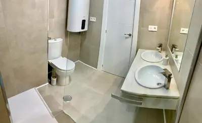 a small bathroom with a toilet and a sink at Espectacular apartamento frente al mar in El Puerto de Santa María