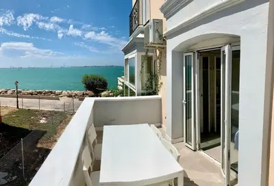 a white table on a balcony with a view of the ocean at Espectacular apartamento frente al mar in El Puerto de Santa María