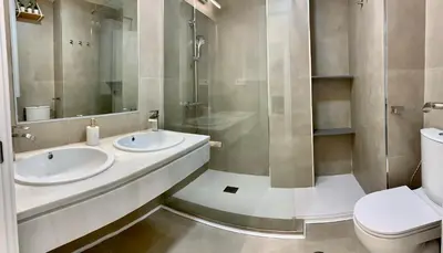 a bathroom with two sinks and a toilet at Espectacular apartamento frente al mar in El Puerto de Santa María