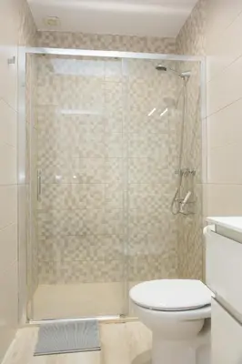 a bathroom with a toilet and a glass shower at ARCO apartamento junto a la Catedral de Cádiz in Cádiz