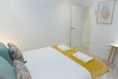 a bedroom with a bed and a blue couch at ARCO apartamento junto a la Catedral de Cádiz in Cádiz