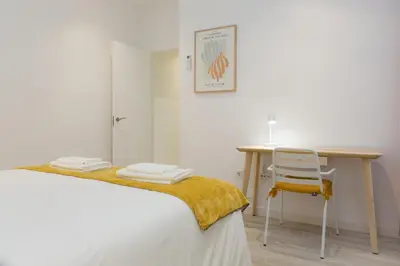 a bedroom with a desk and a chair next to a bed at ARCO apartamento junto a la Catedral de Cádiz in Cádiz