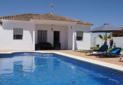 a villa with a swimming pool in front of a house at Casa de la Paz / Andalucia in Hozanejos