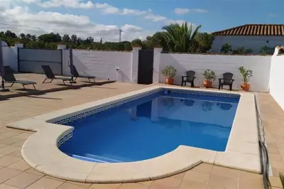 a swimming pool on a patio with chairs around it at Casa de la Paz / Andalucia in Hozanejos