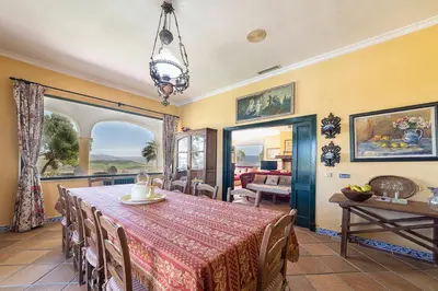 a dining room with a table with a red table cloth at Private Villa Cortijo Sierra y Lago with private swimming pool in Arcos de la Frontera
