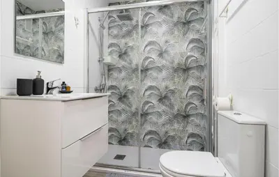 a bathroom with a shower curtain with a toilet at Cozy Apartment In Sanlúcar De Barrameda in Sanlúcar de Barrameda