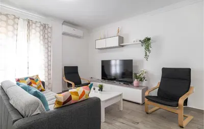 a living room with two chairs and a tv at Cozy Apartment In Sanlúcar De Barrameda in Sanlúcar de Barrameda