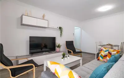 a living room with a couch and a tv at Cozy Apartment In Sanlúcar De Barrameda in Sanlúcar de Barrameda