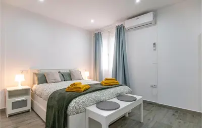 a white bedroom with a bed with yellow towels on it at Cozy Apartment In Sanlúcar De Barrameda in Sanlúcar de Barrameda