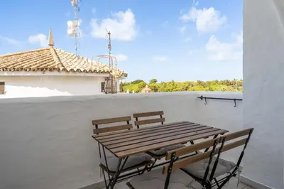 a wooden table and a chair on a balcony at Apartoyou - Vistahermosa Bahía in El Puerto de Santa María
