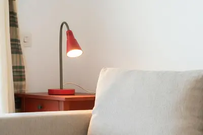 a red lamp sitting on a table next to a couch at Apartoyou - Vistahermosa Bahía in El Puerto de Santa María
