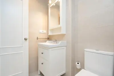 a white bathroom with a sink and a toilet at Apartoyou - Vistahermosa Bahía in El Puerto de Santa María