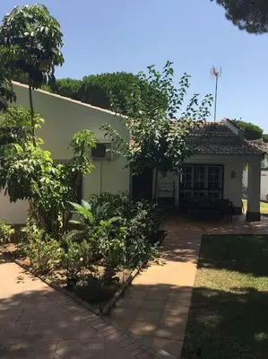 a white house with trees in front of it at Villa Verde con Piscina a 800m de la Playa by Chiclana Dreams in Chiclana de la Frontera