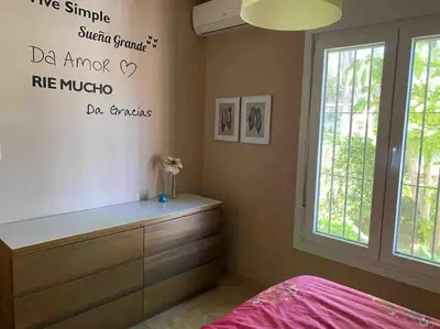 a bedroom with a bed and a dresser and a window at Villa Verde con Piscina a 800m de la Playa by Chiclana Dreams in Chiclana de la Frontera